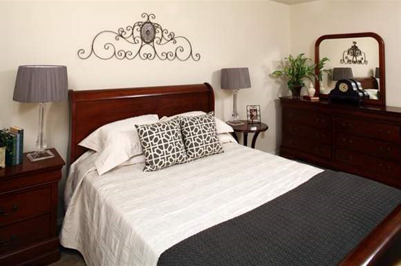 a bedroom with a bed and a mirror on the wall