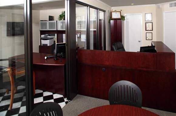 a room with a desk and chairs and a desk with a computer on it