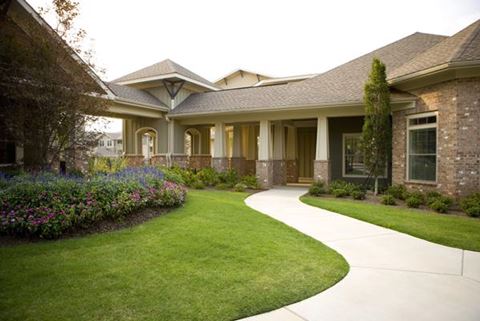 a house with a green lawn and a walkway