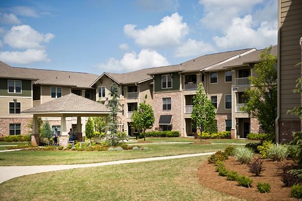 an apartment building with a walkway and grass