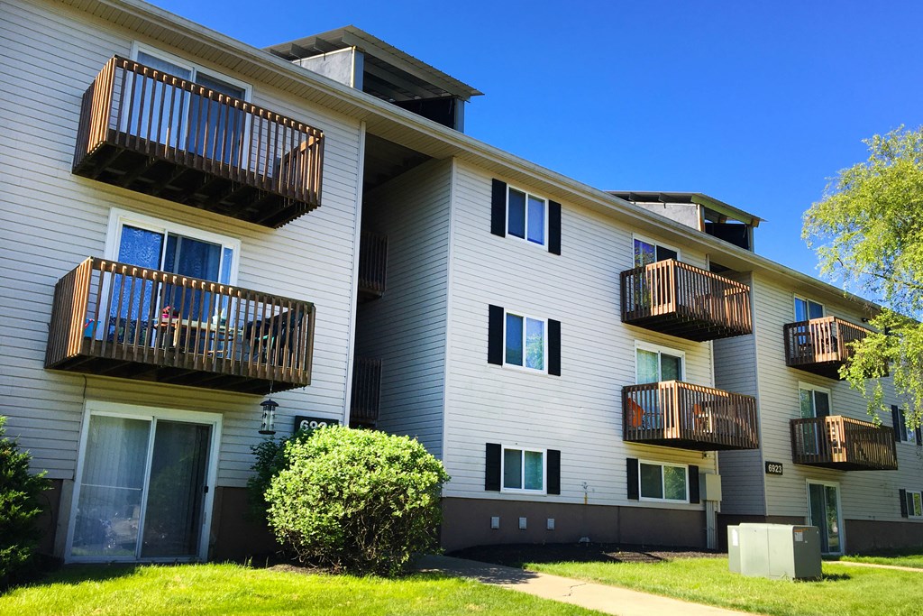 the exterior of a white apartment building with balconies at Oakwood Apartments, Florence, Kentucky