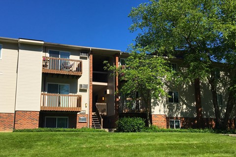 an apartment building with a green lawn and trees at Oakwood Apartments, Florence, KY, 41042