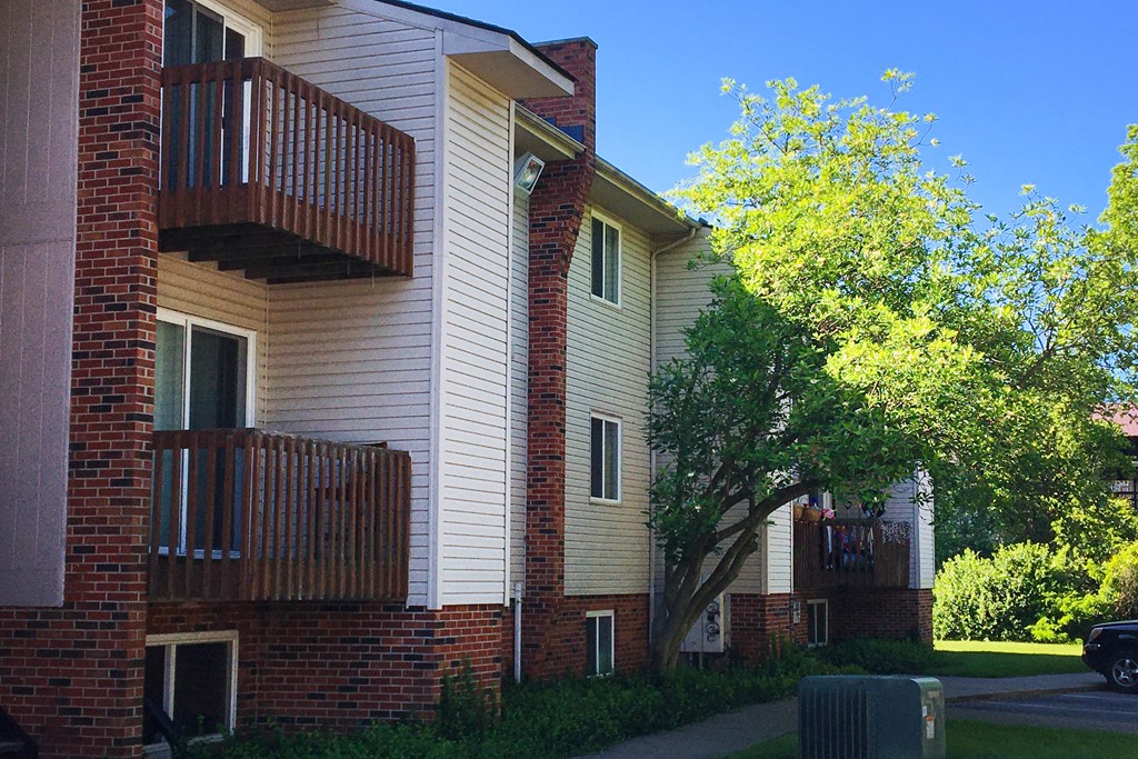 the outside of a building with a tree and a sidewalk at Oakwood Apartments, Florence, KY, 41042