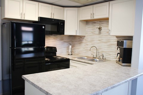 a kitchen with black appliances and a white counter top