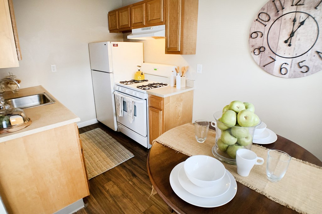 a kitchen and dining room with a large clock on the wall  at Wentworth Estates Apartments, Kentucky