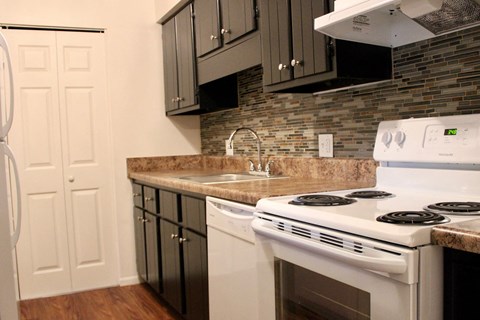 a kitchen with a stove top oven and a sink