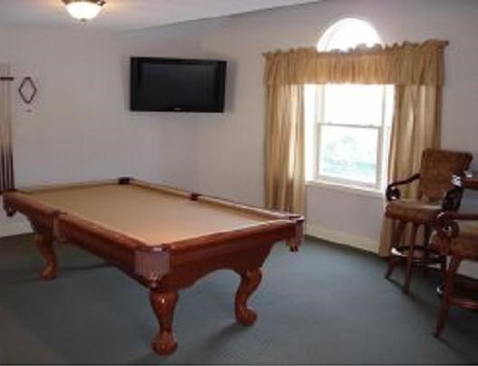 a living room with a pool table and a tv