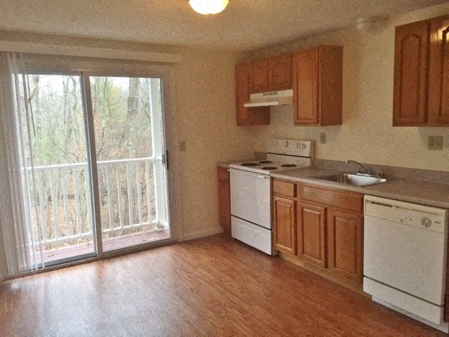 an empty kitchen with a door to a balcony