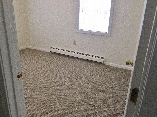 an empty room with a heater on the floor