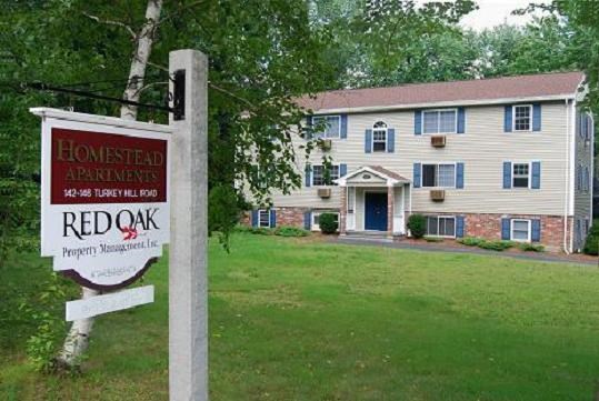 a house with a red oak sign in front of it
