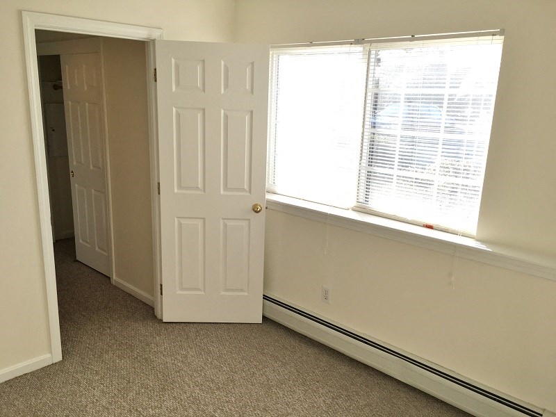 an empty room with a window and a door