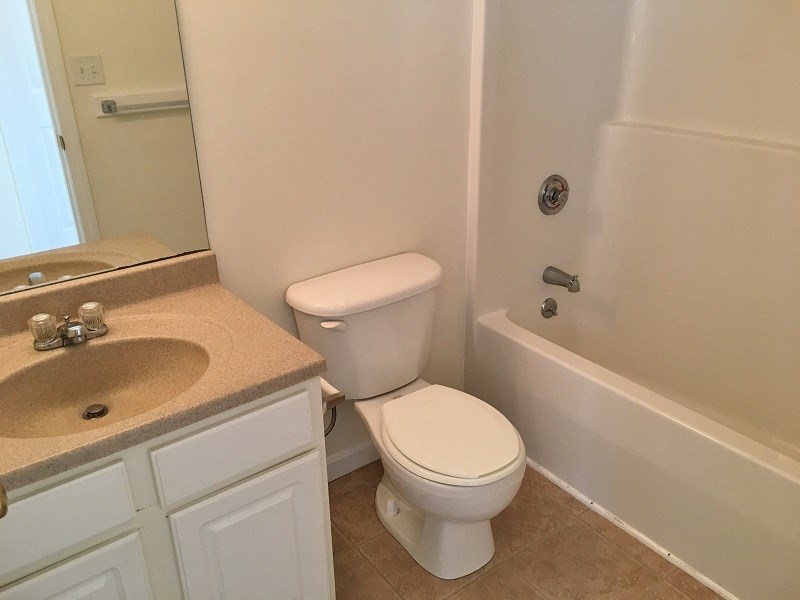 a bathroom with a toilet and a sink and a bath tub