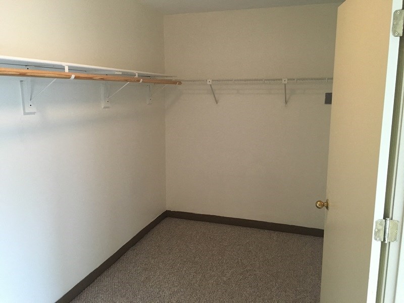 an empty room with a white wall and a white closet