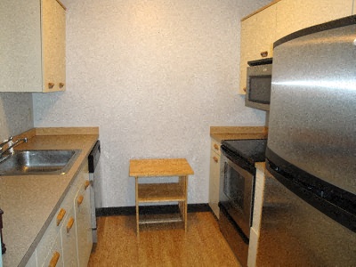 a small kitchen with a sink and a refrigerator