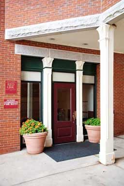 a building with a red door and two potted plants