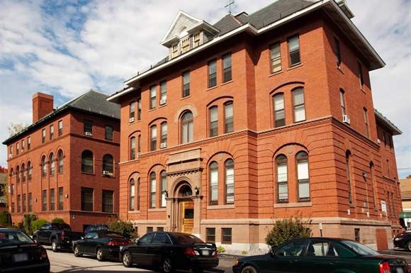 a red brick building with cars parked in front of it