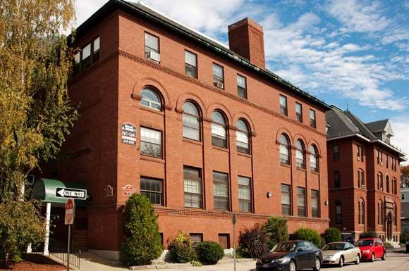 a large brick building with cars parked in front of it