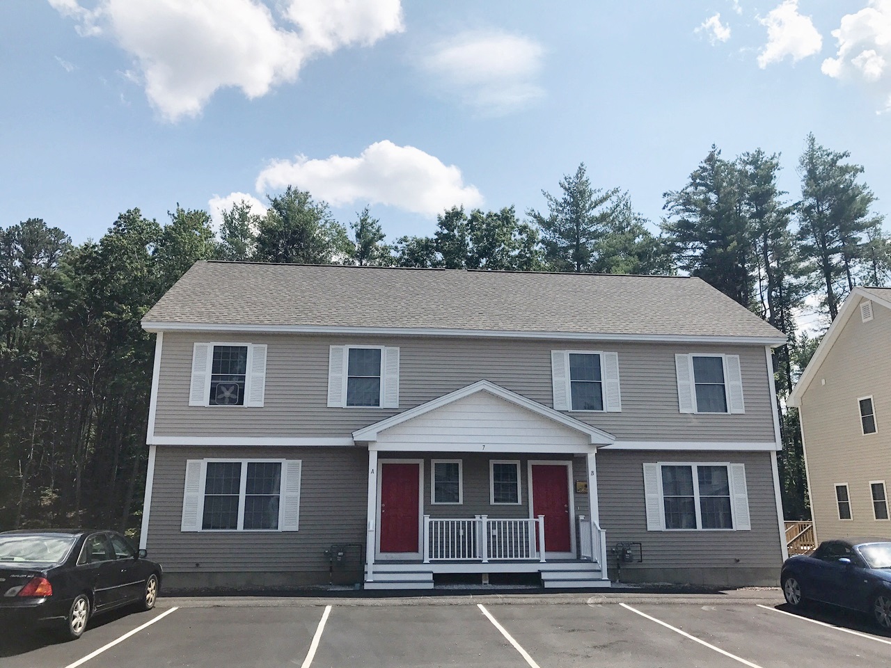 a house with red doors in a parking lot