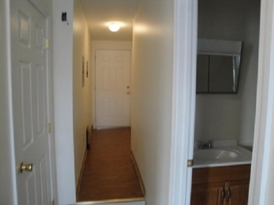 a hallway with a sink and a white door