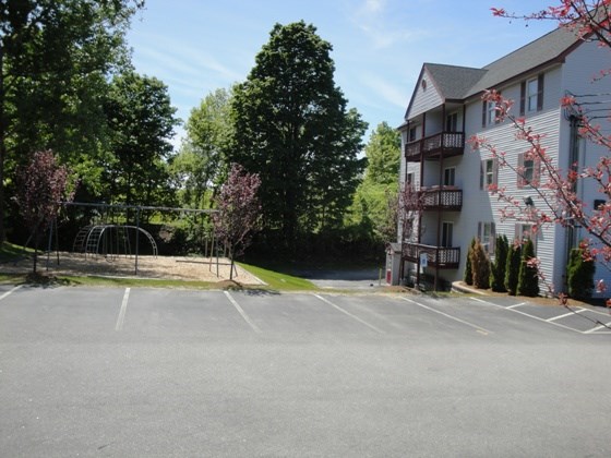 an empty parking lot in front of a house