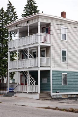 a white house with a balcony on top of it