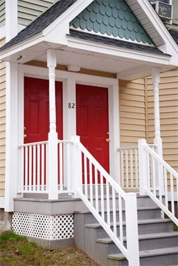 a small house with two red doors and stairs