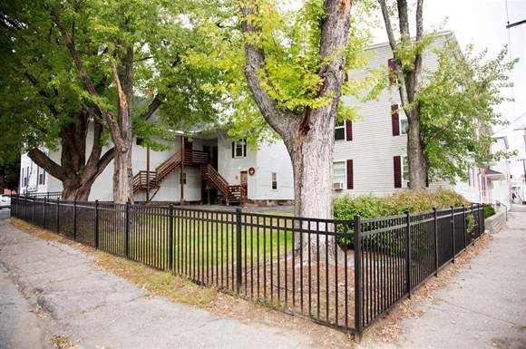 a white house with a fence in front of it