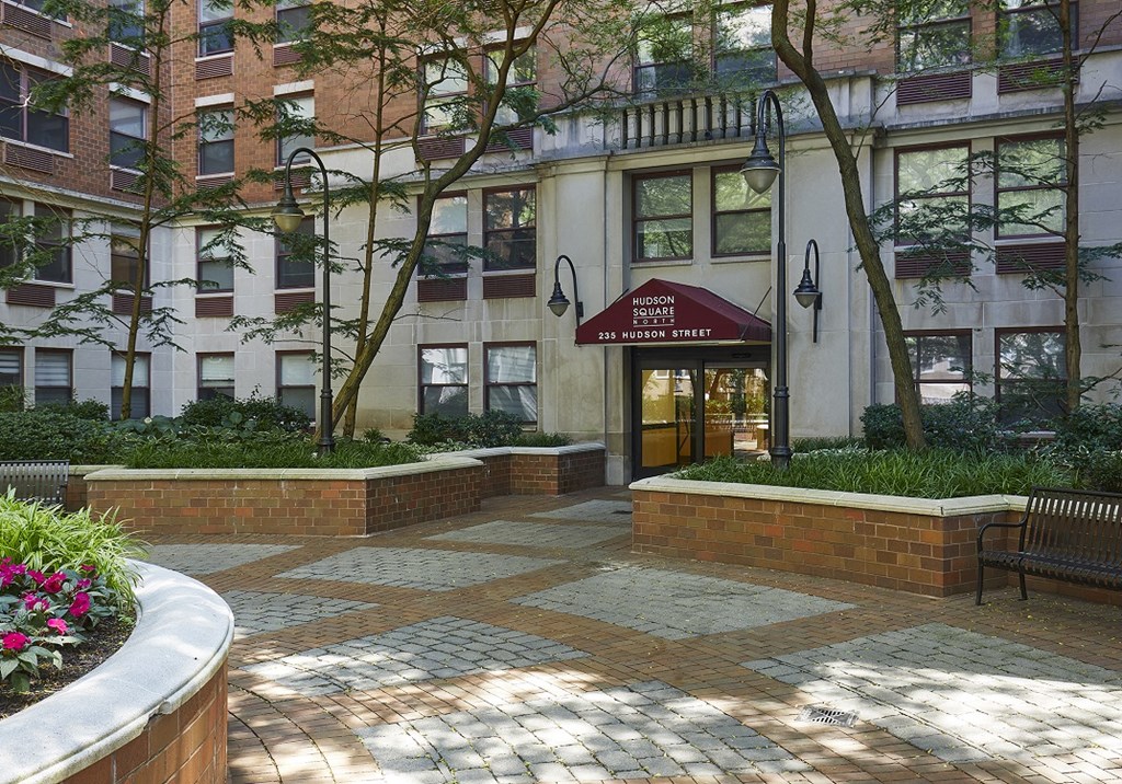 a courtyard in front of a building with a red umbrella