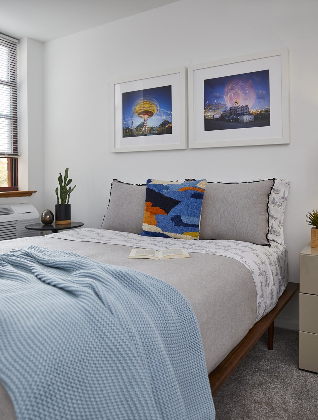 a bedroom with a bed and two pictures on the wall