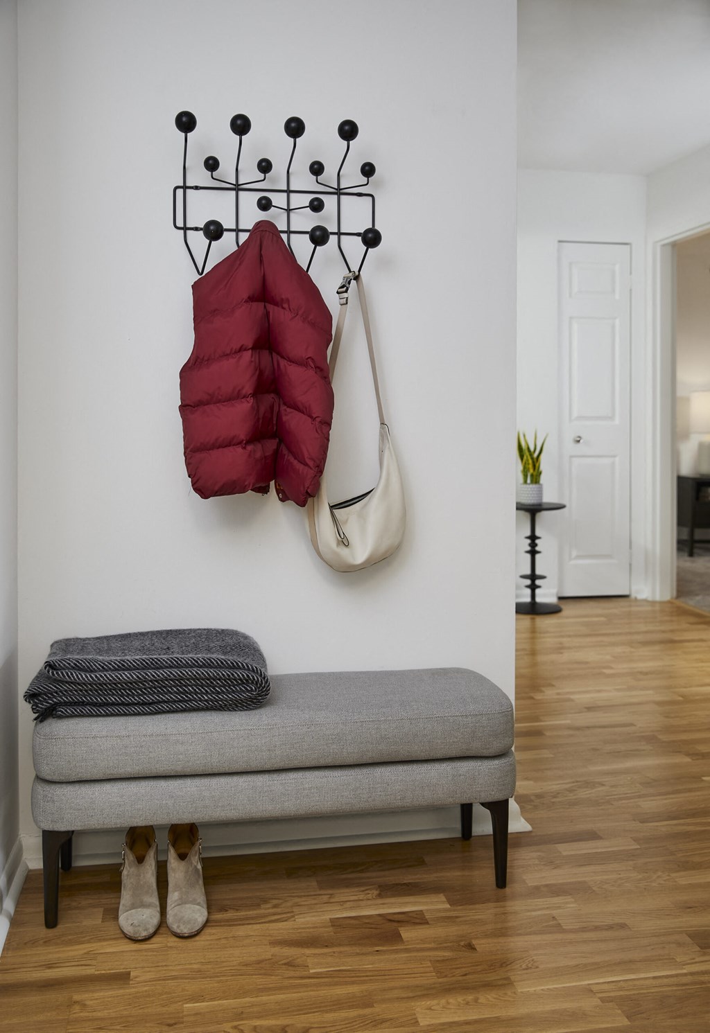a room with a bench and two bags hanging on a wall