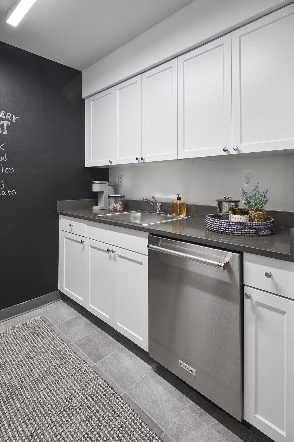a kitchen with white cabinets and a stainless steel dishwasher
