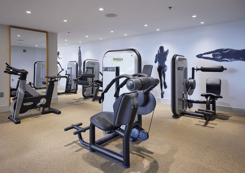 a workout room with various exercise equipment in a hotel gym