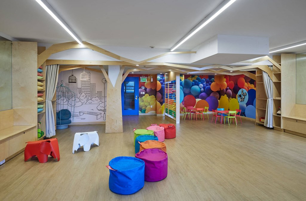 a childrens play room with chairs and balloons