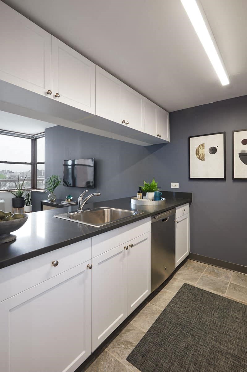 a kitchen with white cabinets and a sink and a window