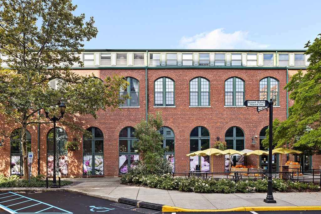 a red brick building with trees and a sidewalk