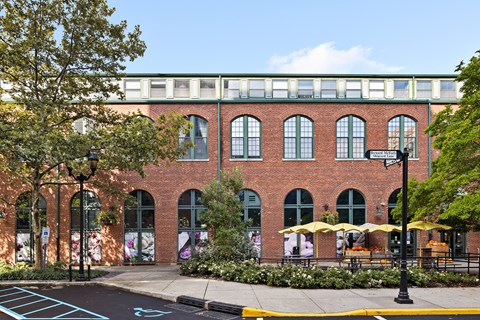 a red brick building with trees and a sidewalk