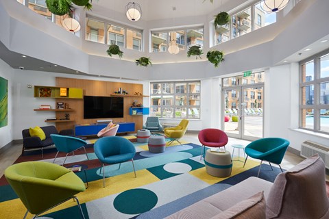 a living room with colourful chairs and a large rug