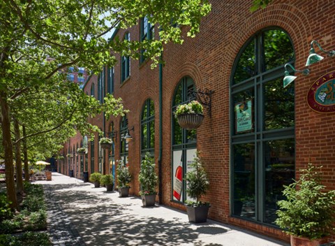 a city street with brick buildings and potted plants