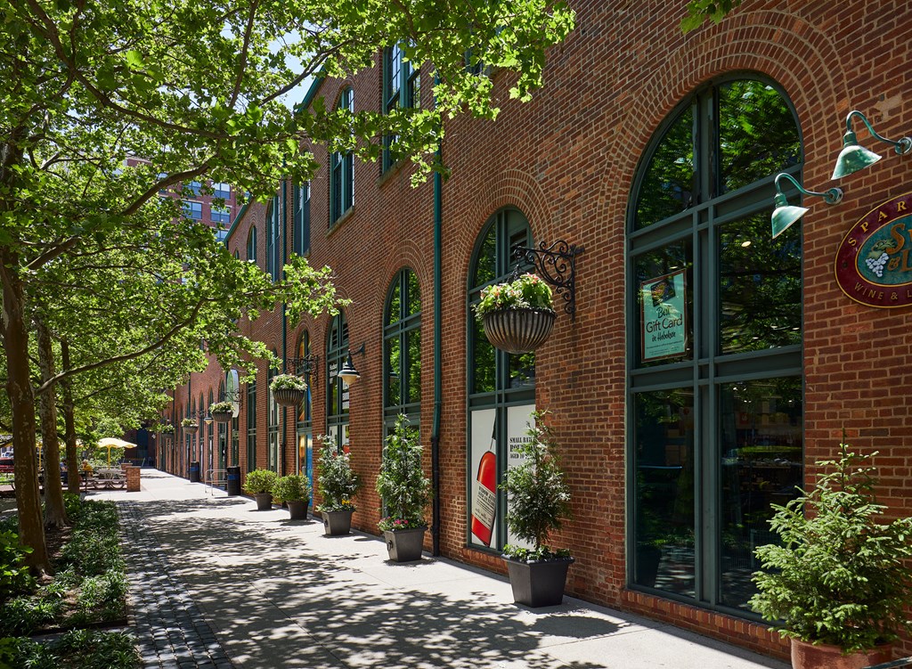 a city street with brick buildings and potted plants