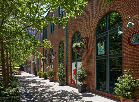 a city street with brick buildings and potted plants