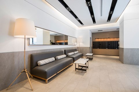 a lobby with couches and a table with a lamp