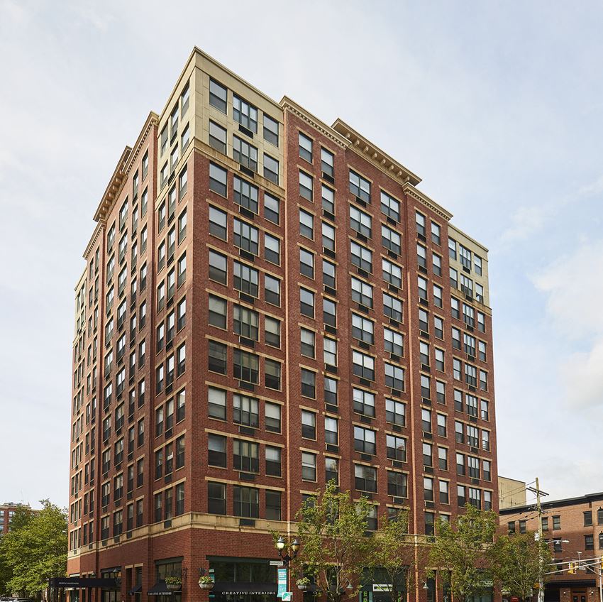 a tall building with many windows and trees in front of it