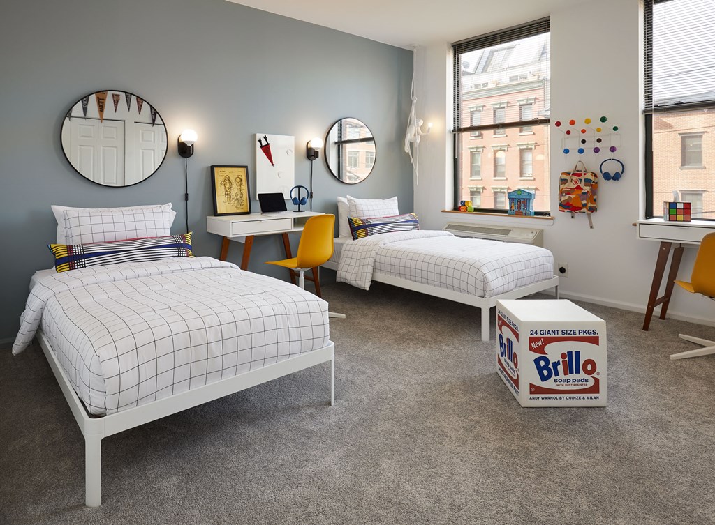 a bedroom with two twin beds and a box of bila