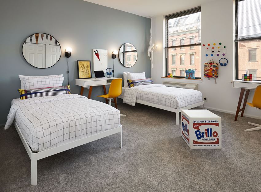 a bedroom with two twin beds and a desk with a computer