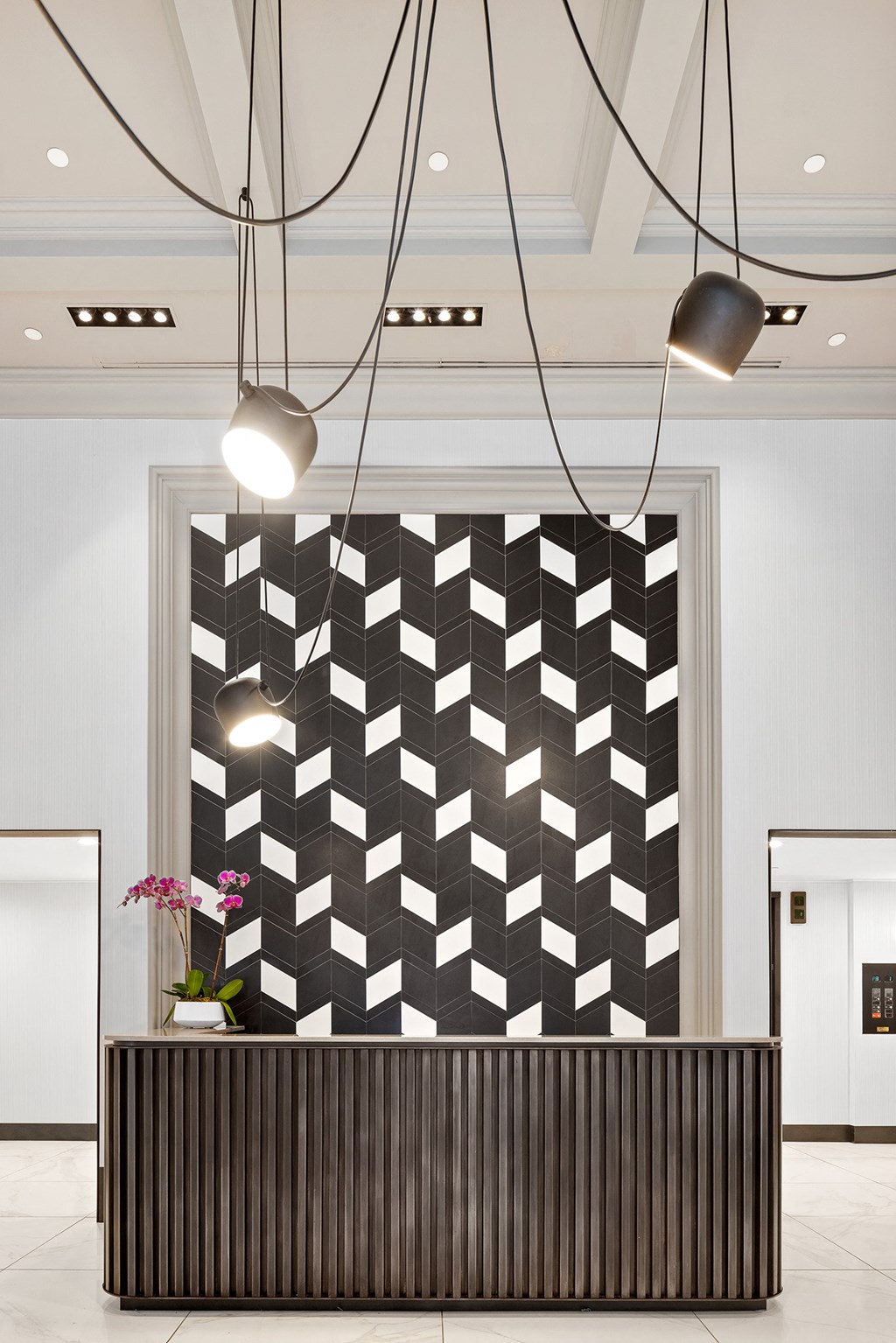 a checkered wall in a lobby with lights and a reception desk