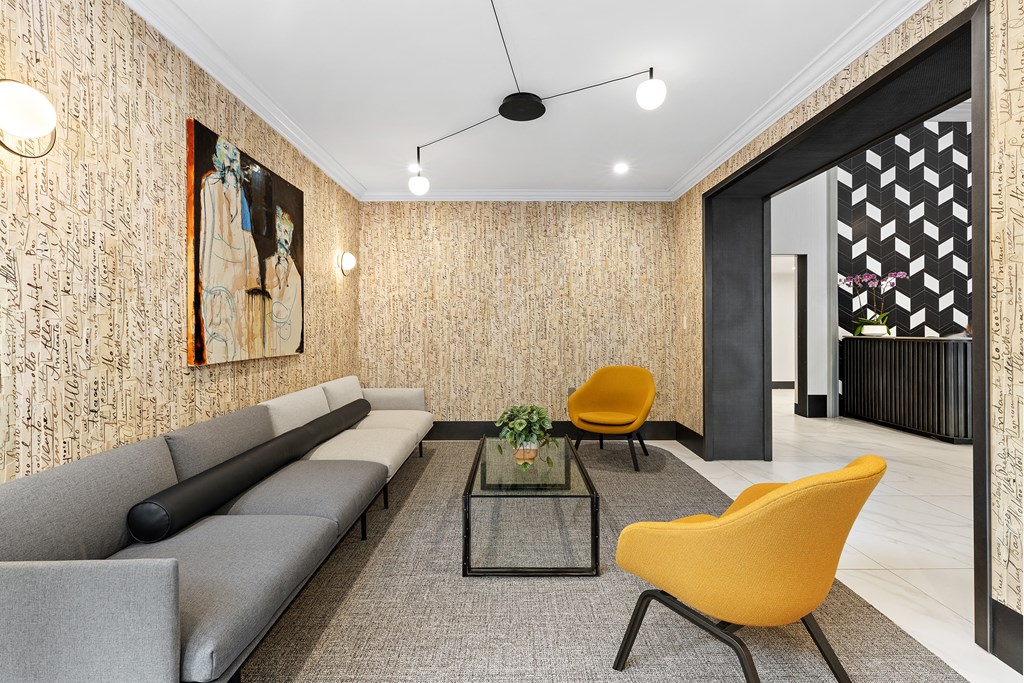 a living room with a gray couch and yellow chairs