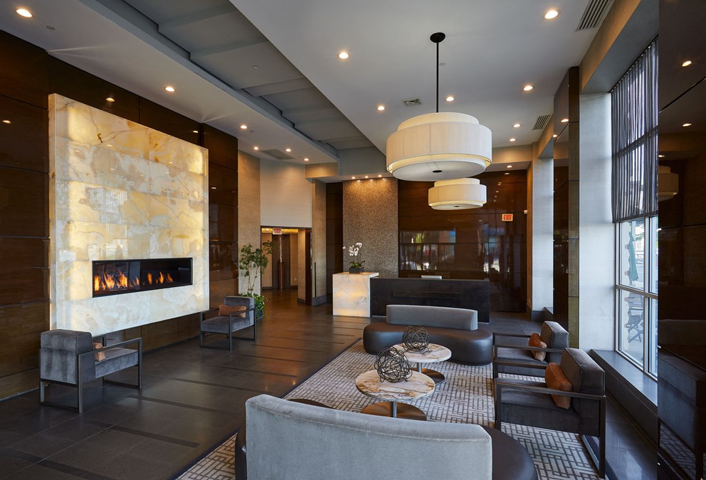 the lobby of a hotel with couches and chairs and a fireplace