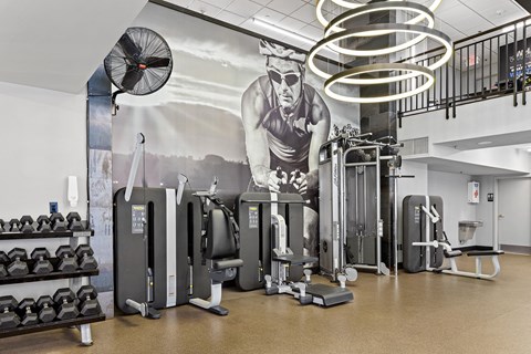 a fitness room with a mural of a man working out with weights