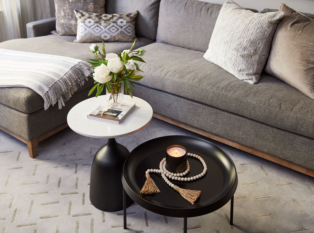 a living room with a couch and a coffee table with a vase of flowers