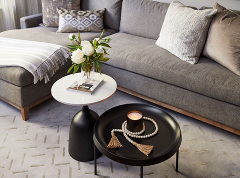 a living room with a couch and a coffee table with a vase of flowers